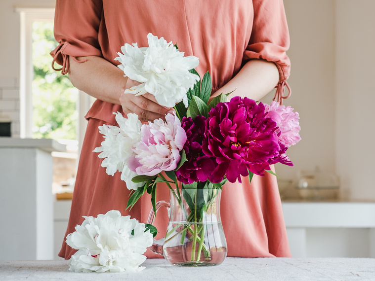 Woman Arranging Flowers in Vase